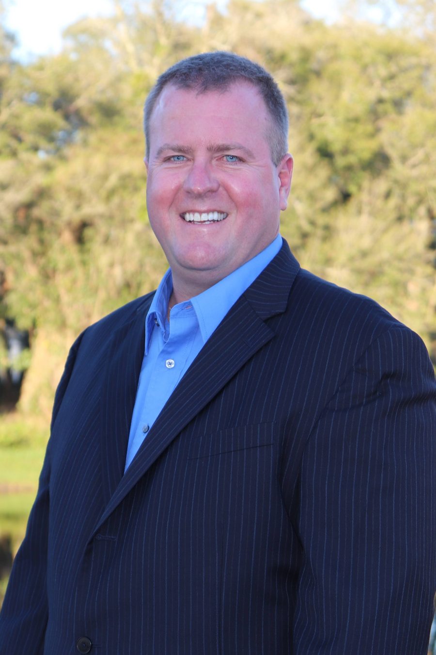 Shawn Ryan, founder of SQUAWKS Business Advisors, in a navy pinstripe suit